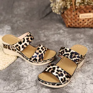 Detailed macro view of leopard print wedge sandals featuring thick platform soles and twin straps