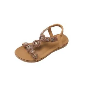 Elegant bohemian flat sandals with intricate beaded flower decorations in tan brown.