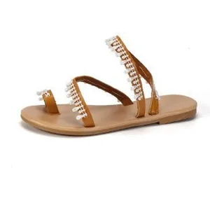 Detailed side view of Bohemian style flat sandals featuring white decorative bead fringe