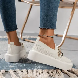Detail of white platform fly-knit sneakers featuring a chunky gold chain detail