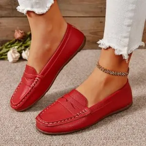 Close-up of stylish red leather loafers with round toe and white stitching detail