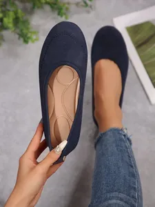 Close-up detail of navy blue women's slip-on ballet flats showing the soft cushioned insole