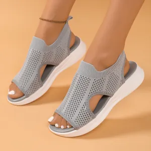 Eine Detailansicht grauer Mesh-Knit-Sport-Sandalen mit einer weichen weißen Sohle.