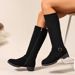 Close-up of black suede knee-high knight boots with side zipper and ankle buckle