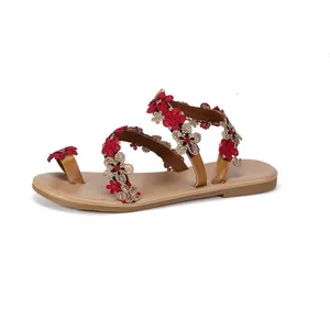 Detail of Bohemian flat sandals featuring intricate red floral embroidery on straps.