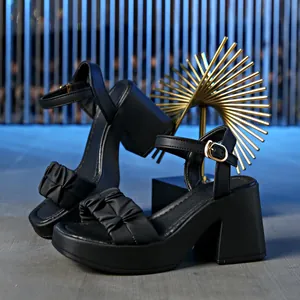 Close-up detail of black fairy style platform sandals with ruffled strap and chunky high heel