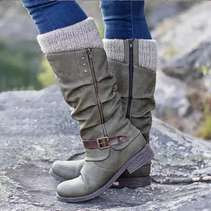 Detailed view of green slouchy knight boots with knit cuff and brown buckle strap