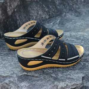 Vue latérale de sandales compensées noires pour femmes avec broderies et surpiqûres