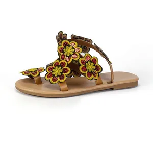 A detailed side profile of Bohemian flat sandals with vibrant embroidered flower decor