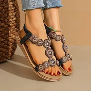 Detailed view of bohemian flat sandals with intricate beadwork and circular patterns.
