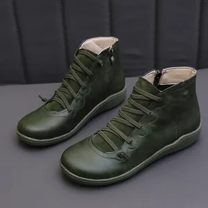 Macro view of stylish green leather casual ankle boots featuring cross-lace design and zipper