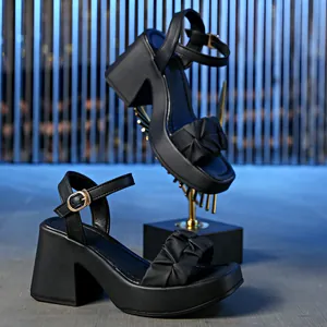 Side view of black block heel sandals with pleated strap and adjustable ankle buckle