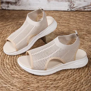 Detailed side view of beige women's mesh wedge sandals with breathable hollow-out design.