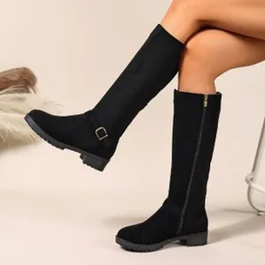 Detailed view of black suede-style knee-high boots with side zipper and buckle accents