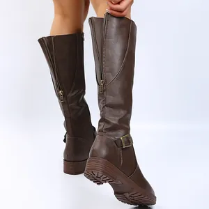 Detailed view of brown knee-high boots with back zippers and adjustable buckle straps.