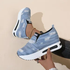 Detailansicht von blauen Denim-Sneakern zum Hineinschlüpfen mit dickem Keilabsatz