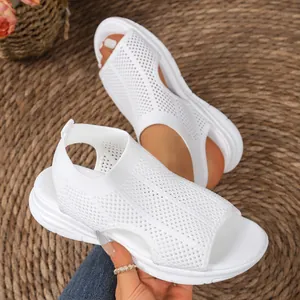 Detailed view of white mesh wedge sandals with breathable hollow design and peep-toe.