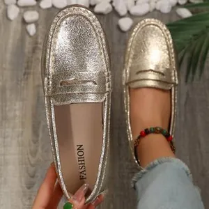 Detail view of shimmering gold slip-on loafers for women with a casual flat design