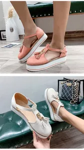 Close-up detail of summer platform sandals featuring stylish tassels in pink and off-white.