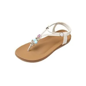 A detailed side view of bohemian flat sandals with colorful beads and floral motifs
