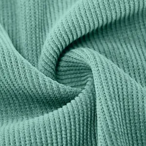 Vista macro della trama del tessuto in velluto a coste verde per camicia da donna