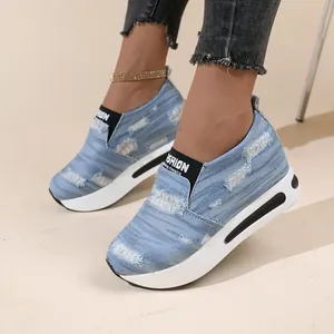 Nahaufnahme von stylischen hellblauen Denim-Plateau-Sneakern mit Distressed-Finish
