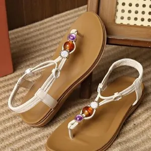 Detailed view of bohemian flat sandals with white straps and colorful decorative beads