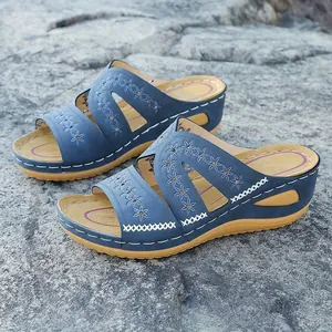 Vue latérale de sandales compensées bleues avec broderie florale élégante et coutures blanches