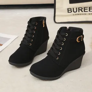 Modische schwarze Keilstiefeletten für Damen mit Schnürung und goldenen Schnallen.