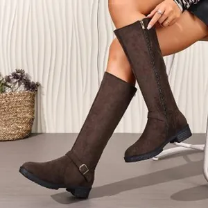 Detail view of stylish brown suede knee-high riding boots with low heel and side zipper.
