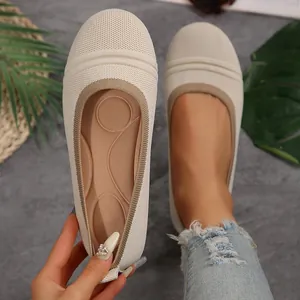 Close-up detail of beige knit flat shoes showing comfortable cushioned inner sole texture