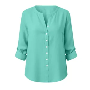 Detail view of light turquoise slub cotton blouse with mandarin collar and rolled sleeves