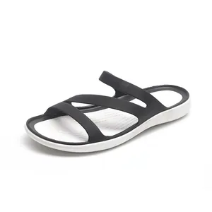 Detail of minimalist black and white women's flat sandals with multi-strap design