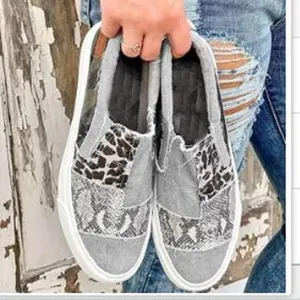 Detail showing women's patchwork canvas loafers with stylish leopard and snakeskin prints.