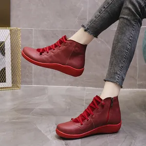 Close-up side view of red leather casual ankle boots with wave-patterned sole