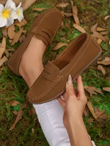 Detailed view of brown flat loafers featuring stylish stitching and round toe design