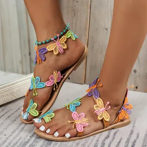 Close-up detail view of colorful butterfly embroidered flat sandals with comfy toe loop design