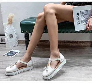 Stylish white platform sandals with tassel detail and T-strap shown on female model