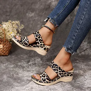 Side view of leopard print platform wedge sandals worn with frayed denim jeans