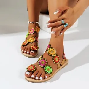 Detail shot of bohemian flat sandals featuring vibrant colorful floral embroidery