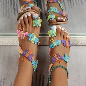Detailed view of women's vacation sandals featuring colorful embroidered butterflies.