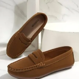 Close-up of brown suede loafers with white stitching details on marble background