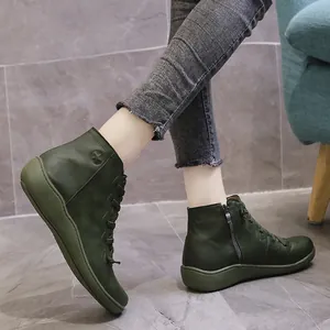 Close-up of green leather short boots with side zipper and star emblem detail
