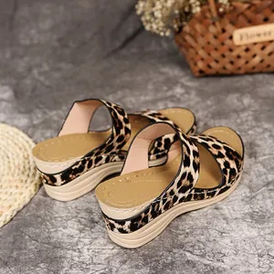Detailed view of stylish leopard print wedge sandals with peep-toe design for beach.