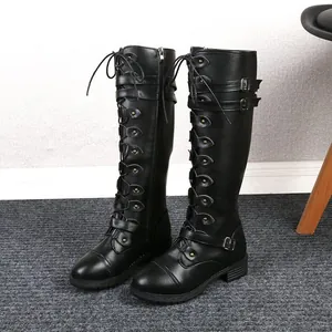 Detail of black knee-high knight boots featuring multiple buckle straps and lace-up design