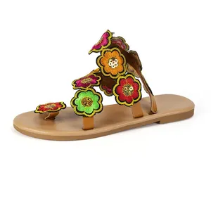 Detailed view of bohemian flat sandals with colorful embroidered flowers and sequins.