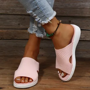 Detailed macro view of comfortable pink knit flat slides worn by a model in summer
