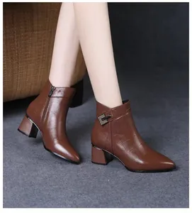 Detailed view of brown croc-embossed leather ankle boots with a block heel and pointed toe