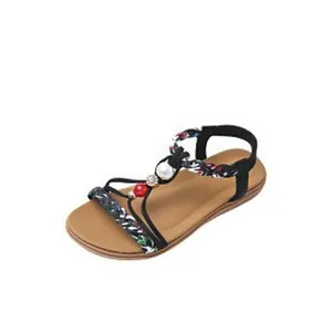 Detailed view of a black bohemian flat sandal featuring floral straps and colorful beads