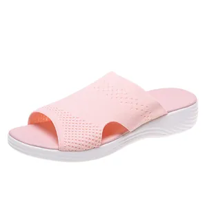 Side view of a pink mesh slide sandal for women featuring a comfortable white flat sole